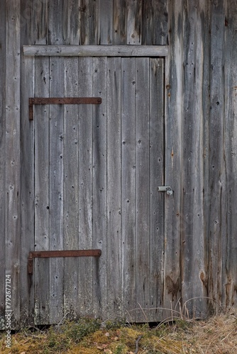 Locked weathered door on a wood building.