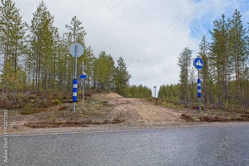 Snowmobile trail crossing the road in cloudy spring weather, Oulanka National Park, Kuusamo, Finland. photo
