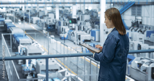 Photography Young Asian Female Engineer Standing on a Platform, Using Tablet Computer at an Electronics Factory