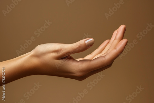 Close up of woman hand with palm facing upwards isolated on brown background. Female hand showing empty hand. Woman holding your beauty product