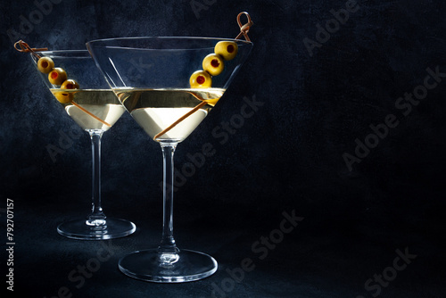 Martini. Two glasses of dirty martini cocktails with vermouth and olives, aperitif in a bar, side view with copy space