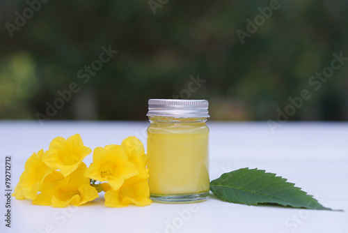 Bottle of homemade Thai herbal ointment, balm.Decorated with yellow flower.Concept, Thai local wisdom to use fragrant medicinal herbs to make inhaler and massage balm.