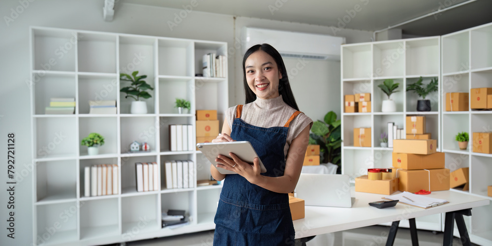 Entrepreneur startup business woman sme holding tablet. Small Online Business Owner, Online Marketing and Product Packing and Delivery Service. E-commerce concept Entrepreneur startup business woman sme holding tablet. Small Online Business Owner, Online Marketing and Product Packing and Delivery Service. E-commerce concept