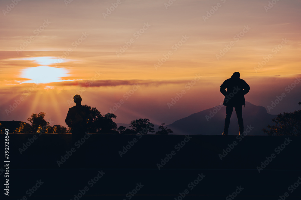Silhouette of a person standing and admiring the scenery When the sun is rising On the viewpoint of Doi Inthanon.