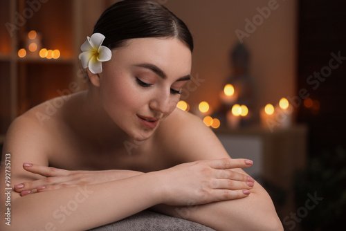Spa therapy. Beautiful young woman lying on massage table in salon, space for text