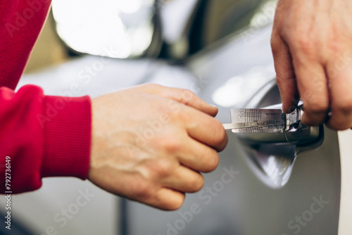 Man thief opening car with a special thief key