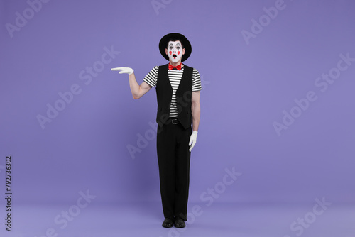 Mime artist making shocked face on purple background © New Africa