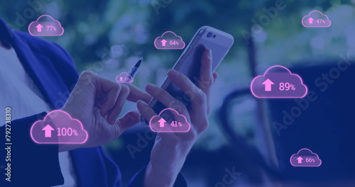 Image of pink cloud symbols uploading data over caucasian businesswoman using smartphone