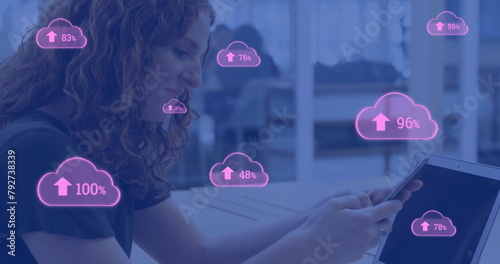 Image of pink clouds uploading data over caucasian businesswoman using smartphone and laptop