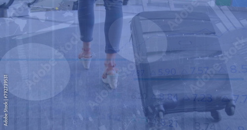 Image of financial data processing over caucasian woman walking with suitcase on street
