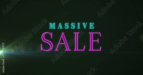 Image of massive sale text banner against light spot on black background