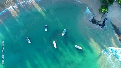 Aerial drone landscape over boats docked in sandy ocean bay Turtle beach with waves in channel Hikkaduwa Sri Lanka travel holidays tourism Asia photo