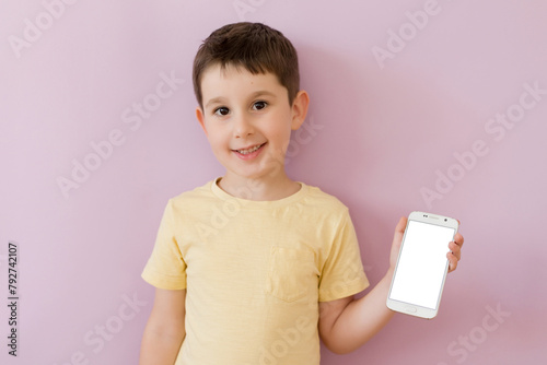 Boy with smartphone on pink background