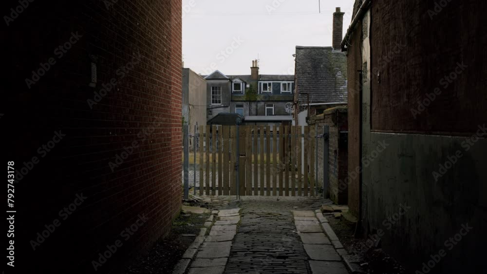Gloomy view on a typical back alley view between houses in United Kingdom