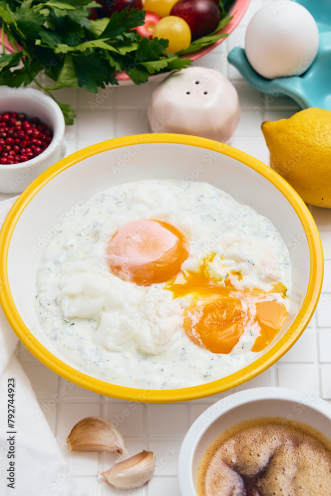 Cilbir or Turkish Eggs in white bowl. Traditional Turkish breakfast, Turkish cuisine concept. Cilbir or Turkish Eggs in white bowl. Traditional Turkish breakfast, Turkish cuisine concept.