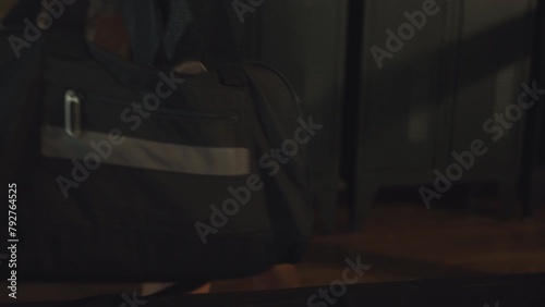 Closeup female athlete carrying sports bag, ready to change and start her workout session in gym locker room photo