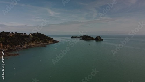 Aerial 4K Drone footage off the coast of Cancele, Brittany, France. Footage shows a small island our in the beautiful blue sea. photo
