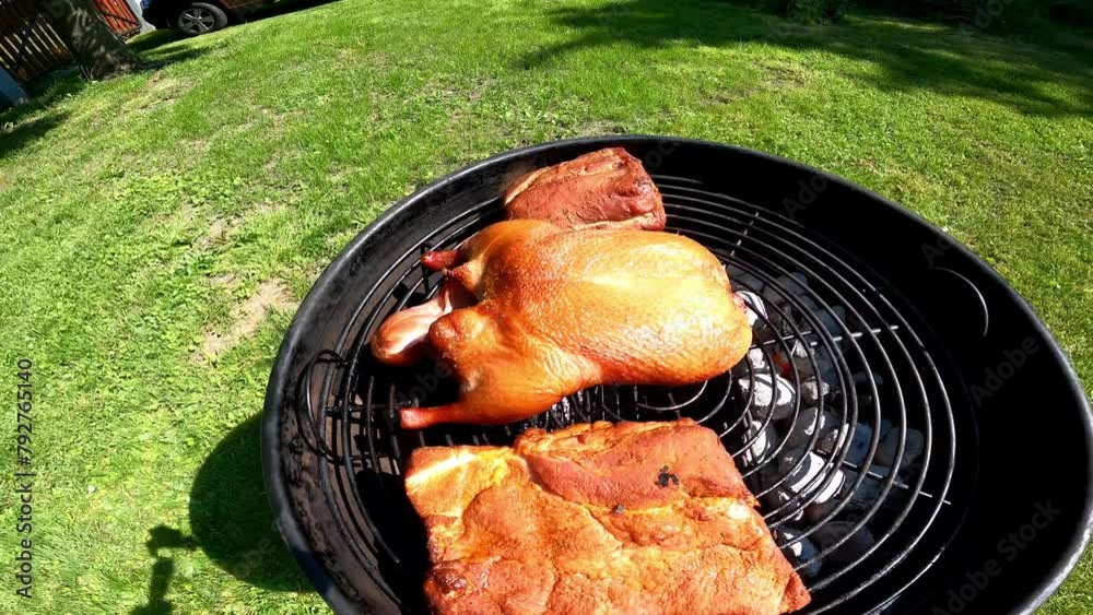 Roast duck and pork on the grill on a summer day.