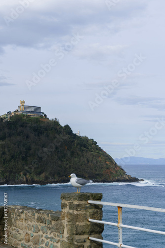 lighthouse on the island with castle on top and seagull watching  photo