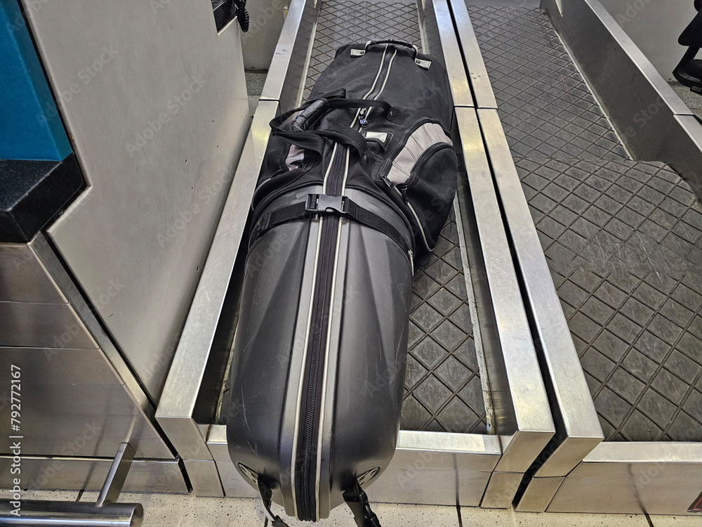 Naklejka premium Black Suitcase on Escalator