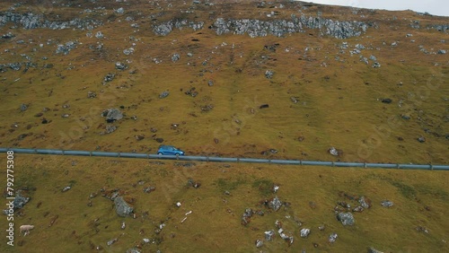 On the Road: Cinematic Drone Footage Tracking Car Amidst Stunning Faroe Islands Scenery. photo