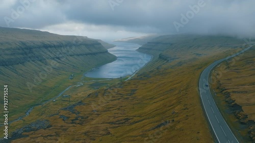 Scenic Road Trip: Aerial Views of Car Followed by Drone Capturing Stunning Faroe Islands Landscape. photo