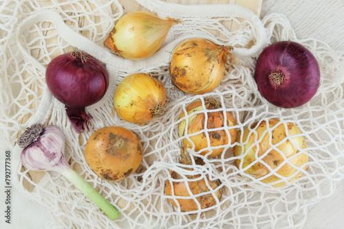 Set of farming onion on a white wooden background. Purple and yellow onions. Rural style.