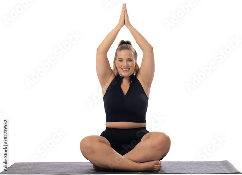 A young caucasian female plus size model sits cross-legged on white background, copy space © wavebreak3