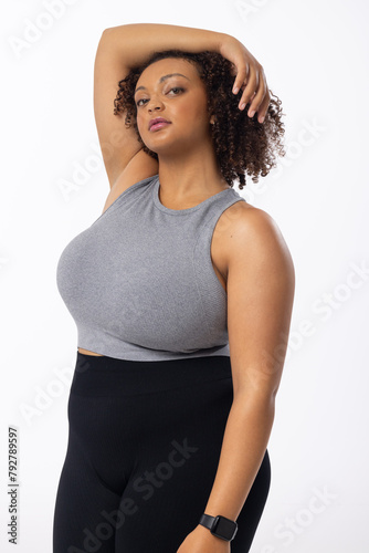 A biracial young female plus size model poses on white background