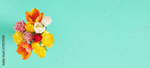Multi-colored bouquet of tulips on a mint table background. flat lay, top view.