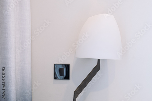 A white lampshade of a room floor lamp on a white wall background
