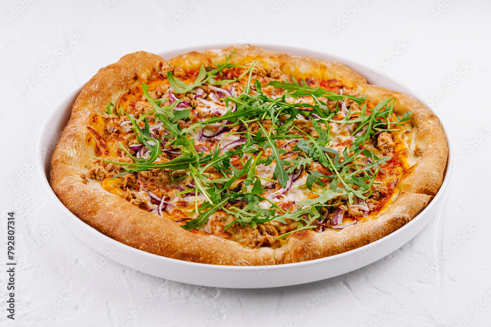Fresh tuna and arugula pizza on white plate