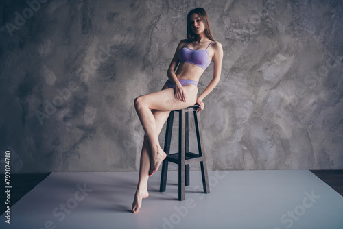 Full body length photo of pretty woman in violet noname brand lingerie sitting chair isolated on grey wall background photo