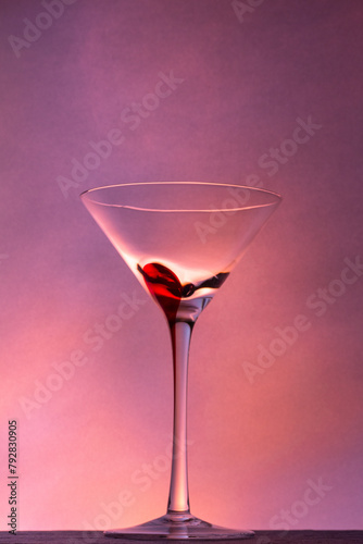 Martini glass on a beautiful long stem with a red accent on a beautiful colorful background