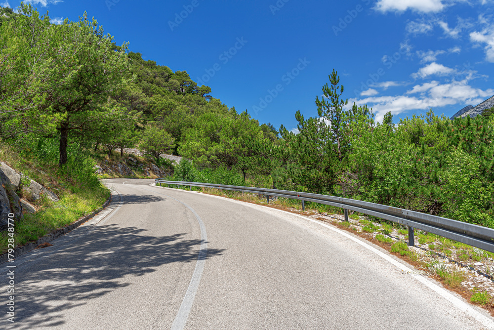 Country road with rocky mountains in the background.