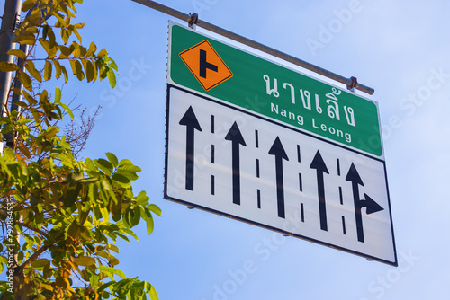 Road information sign with directional arrows against blue sky at Bangkok, Thailand. Nang Leong direction
