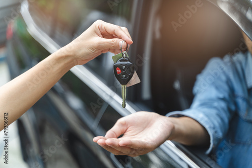 Buy second-hand auto or rent a car concept, Close-up hand of used car agent giving an auto key to client. © Pormezz