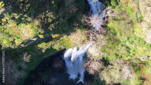 Aerial footage of Seimeira de Vilagocende Waterfall cascading on rocks in Fonsagrada, Lugo, Spain photo