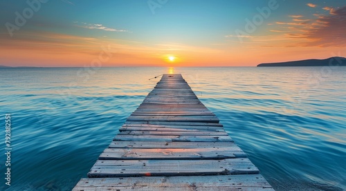 Beautiful sunrise over the sea with a wooden pier, blue sky and calm water in summer time © DWN Media