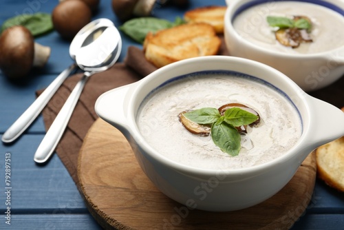 Fresh homemade mushroom soup served on blue wooden table, closeup