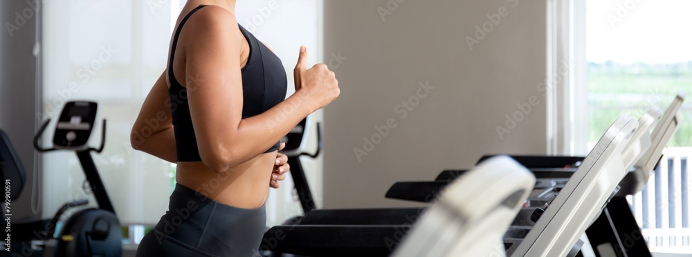 Fototapeta premium Young woman workout with jogging and exercise on machine treadmill in fitness gym sport, woman exercise with cardio training jogging, healthcare and motivation, leisure and health for strength.