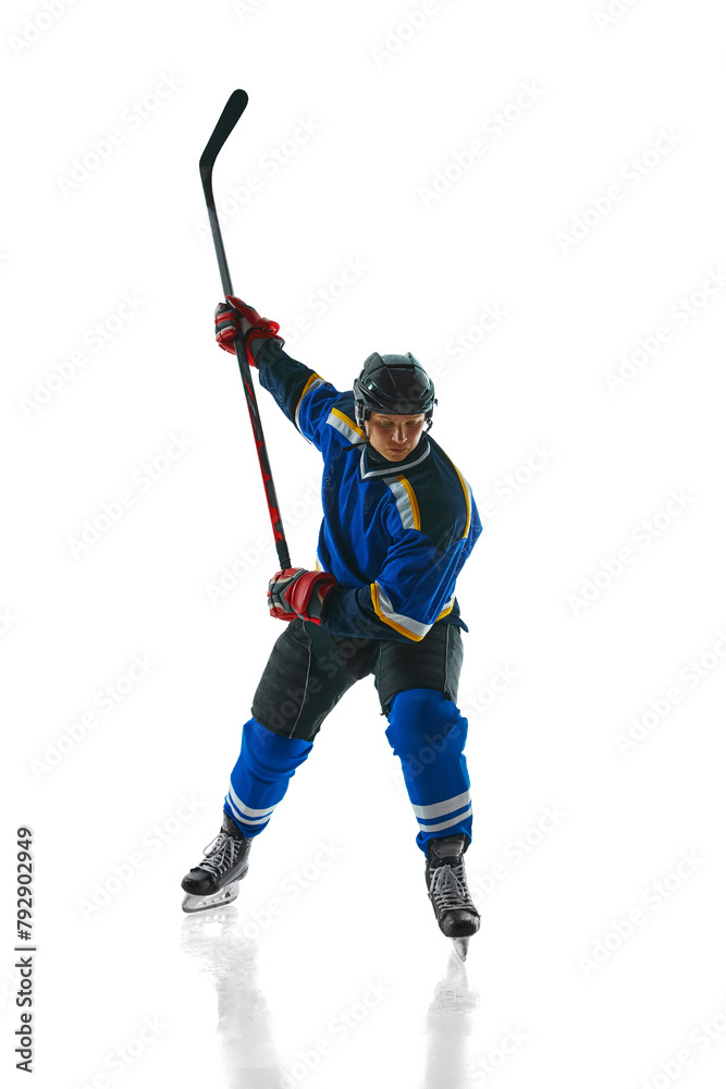 Ready to attack, athletic hockey player, geared up and focused, glides with stick held high against white studio background. Concept of professional sport, competition, movement, tournament, match. Ad Ready to attack, athletic hockey player, geared up and focused, glides with stick held high against white studio background. Concept of professional sport, competition, movement, tournament, match. Ad