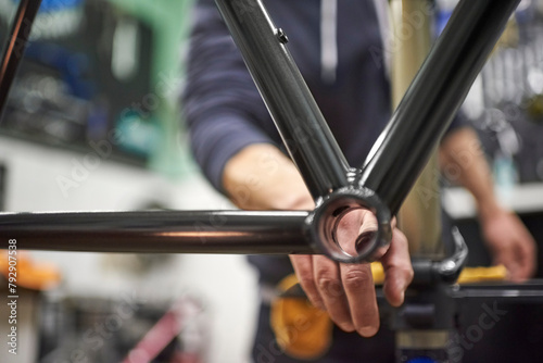Unrecognizable person assembling a bicycle in his bike shop as part of a maintenance service. Real people at work. photo