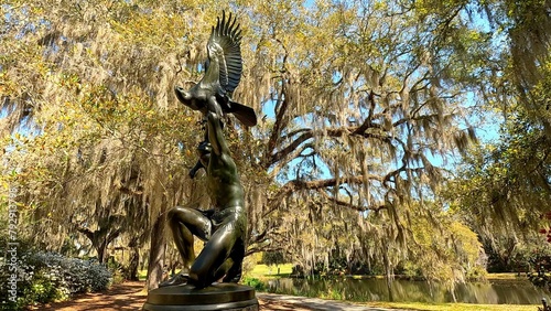 Statue of native American with bird against live oak tree with spanish moss