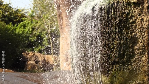 Waterfall falling from rock about baobab photo