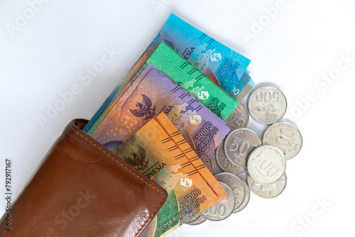 Top view of Indonesian Rupiah money and coins in wallet on a white background