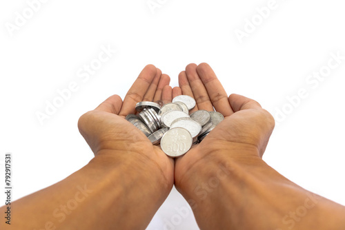 Handful of coins in palm. Male hands holding Indonesian Rupiah coins.