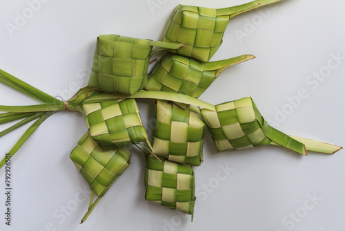 Ketupat wrap, woven young coconut leaves, before cooked. Isolated on white background photo