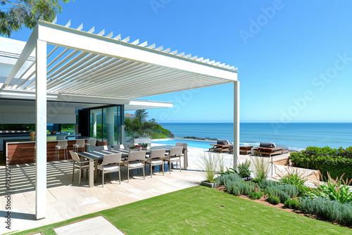 beachfront property featuring a large bioclimatic pergola, providing a dynamic outdoor living area that adjusts to coastal climates © Davivd