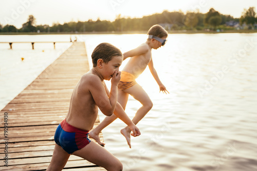 Boys jumping into a lake from a bridge. photo